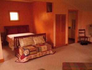 Cozy retreat with a single bed, comfortable chair, and natural light.
