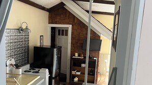 Cocina compacta con refrigerador, estufa y un pequeño comedor.