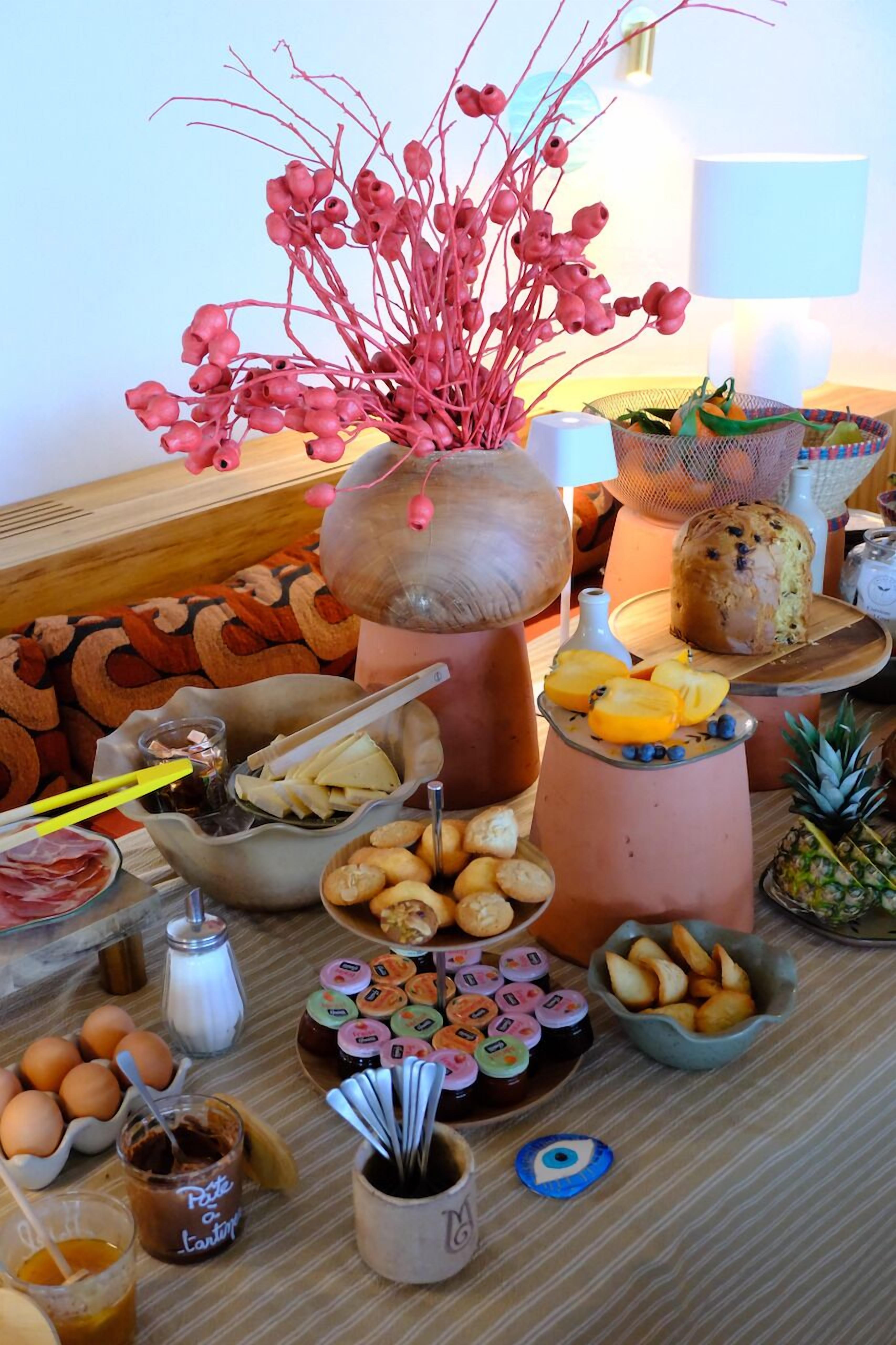 A buffet table with various food items, including fruits, pastries, and condiments.