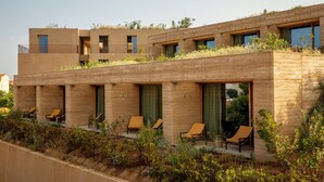 A modern building with a flat roof, multiple balconies, and outdoor seating areas. -  Hôtel Mylos - Cargèse (Cargèse)