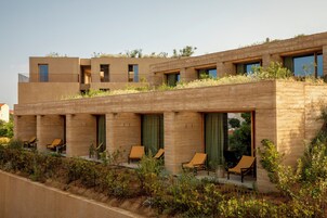 Un edificio moderno con techo plano, varios balcones y zonas de estar al aire libre.