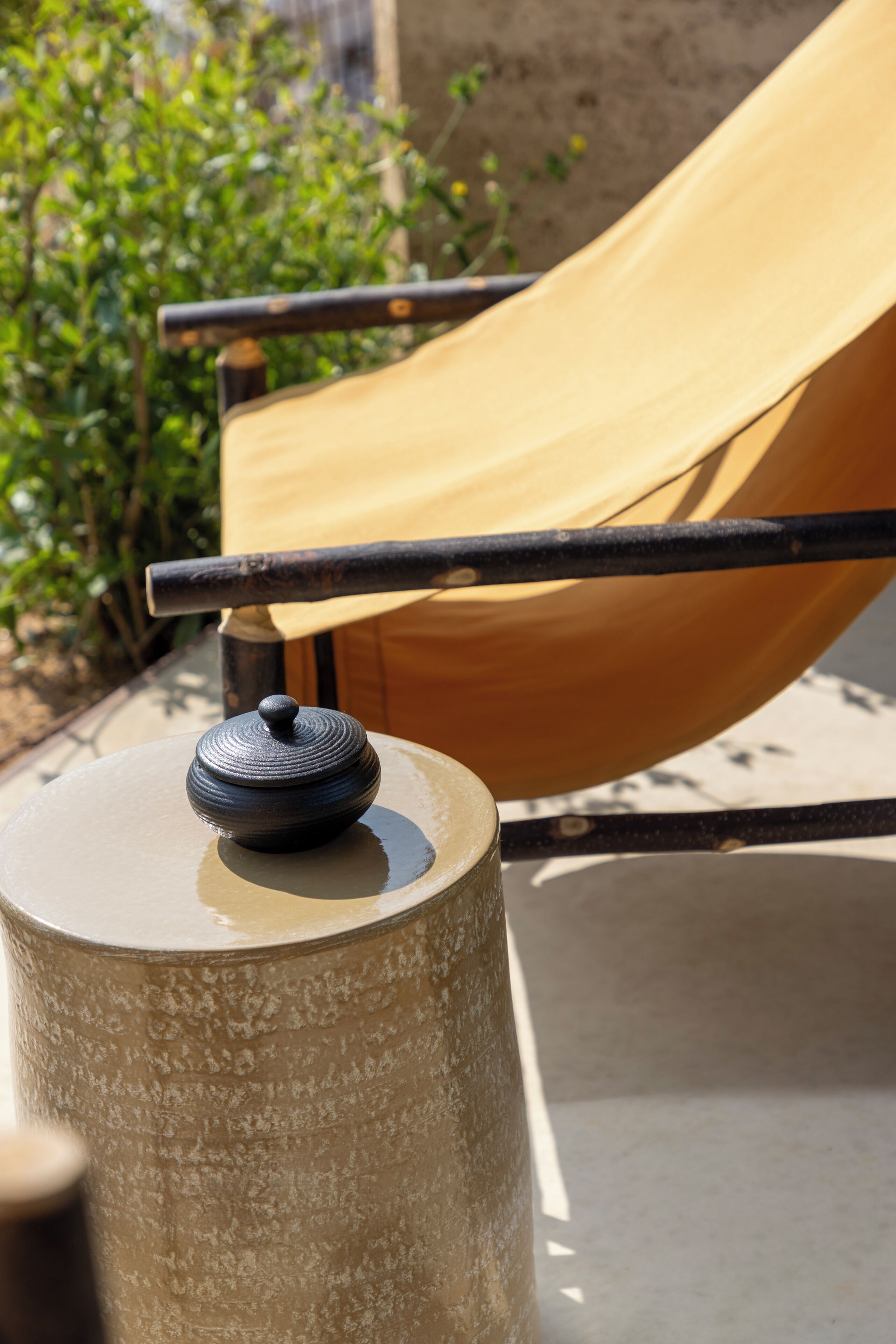 A concrete pillar with a lid, a metal bar, and a yellow slide in the background.