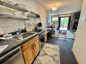 A modern kitchen with a dishwasher, stove, and wooden cabinets. - Lutsen Ski-In/Ski-Out | Lake View | Pet-Friendly (Lutsen)