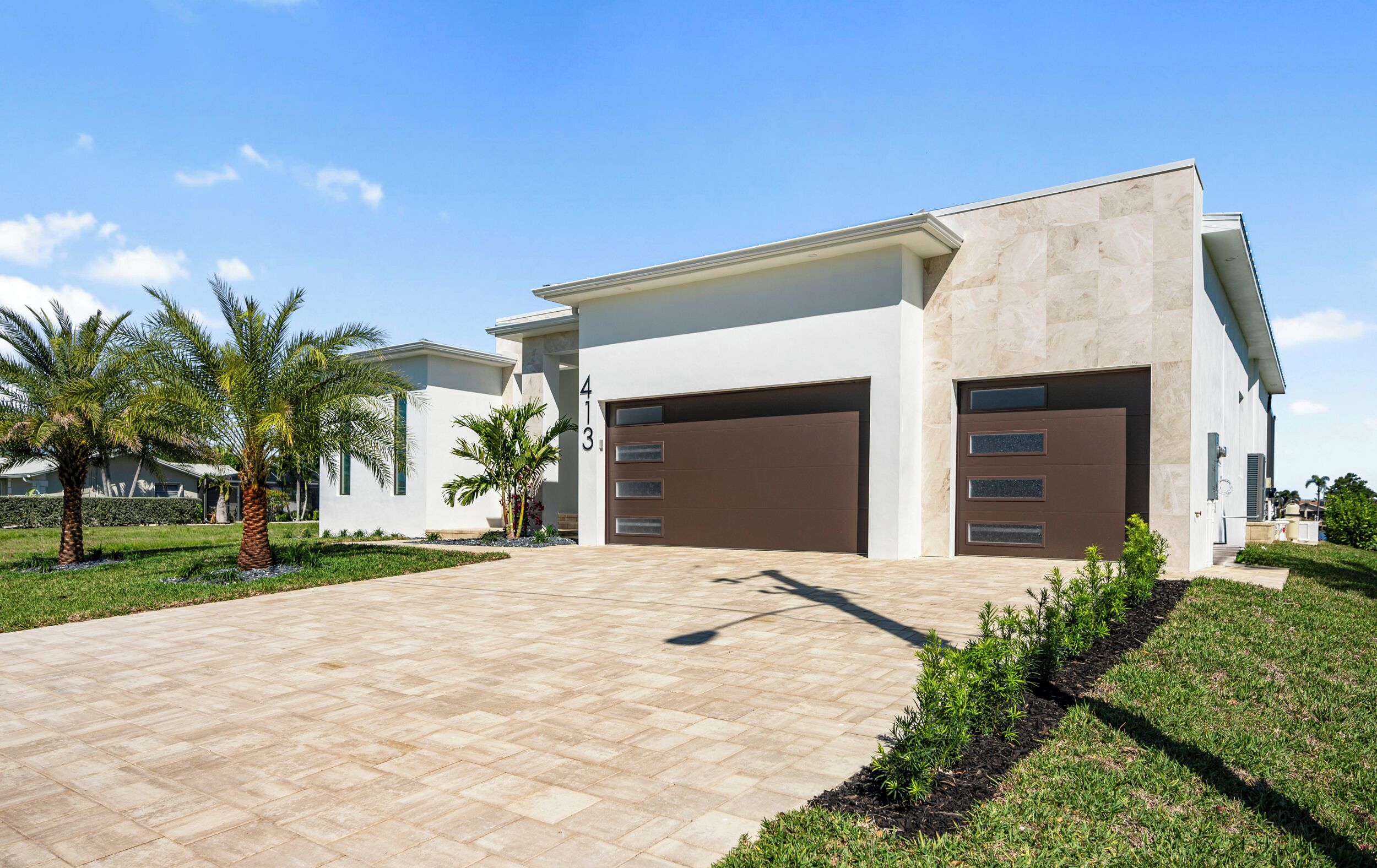 A modern two-story house with a driveway leading to a garage.
