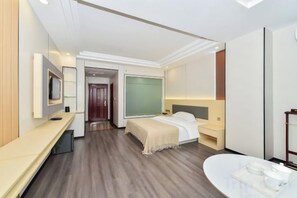 Una habitación de hotel moderna con cama, mesita de noche, televisión y baño con bañera y lavamanos.
