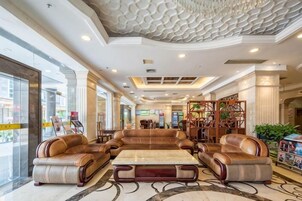 Un vestíbulo con una amplia zona de estar, un bar de café y una estantería.