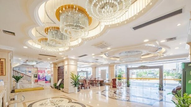Un vestíbulo amplio con candelabros, una escalera y una zona de estar.