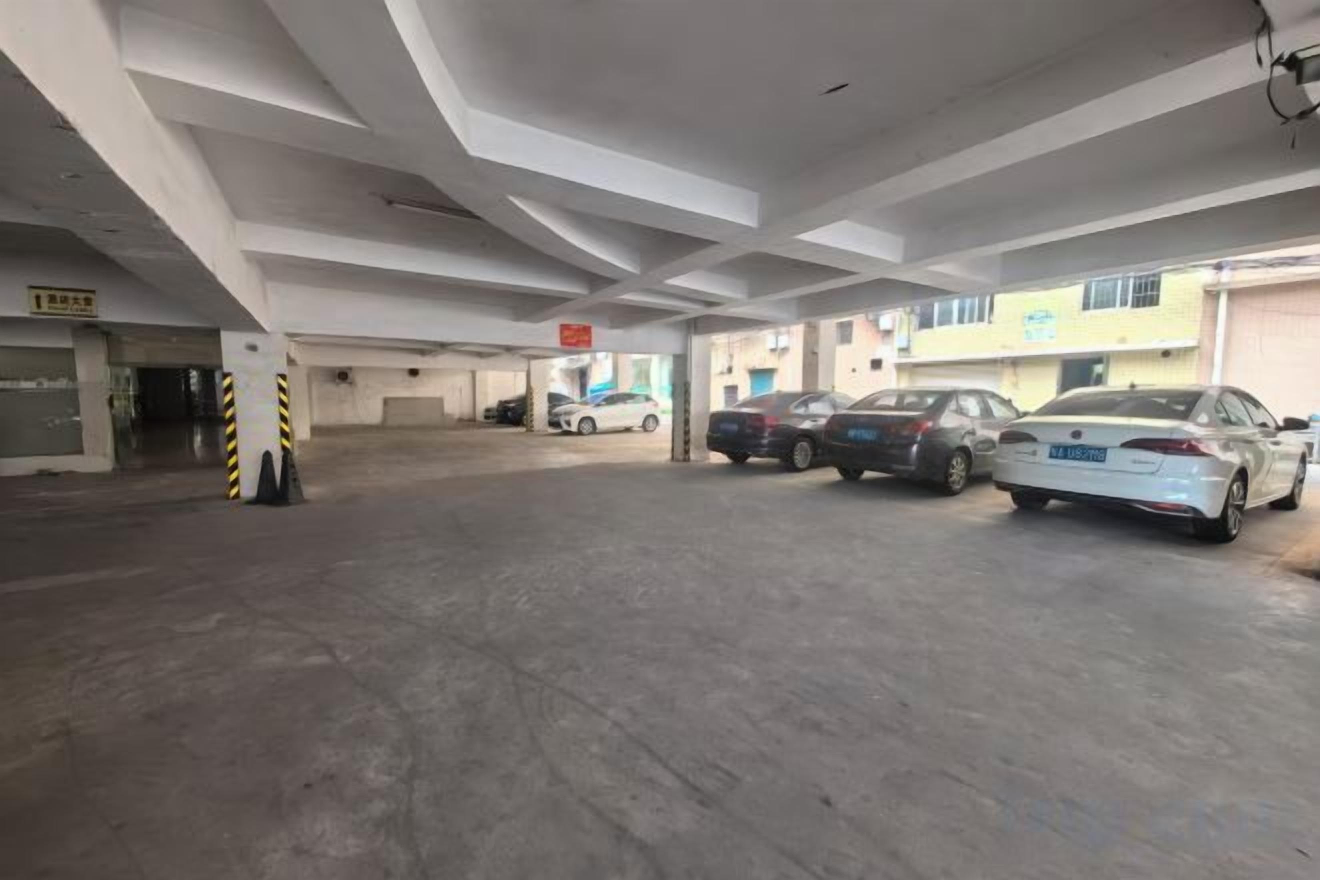 A multi-level parking garage with several cars parked, concrete floors, and a building with signage in the background.