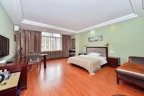 Ein Hotelzimmer mit Bett, Schreibtisch, Stuhl und Fernseher.