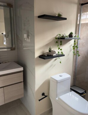 Een douche, handdoeken, zeep, toiletpapier