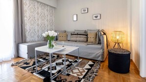A modern living room with a sofa, a coffee table, a rug, and a lamp. - Kosmos Serenity - 1BR, Central Athens (Athina)