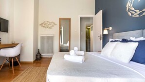 A modern hotel room with a large bed, a desk, and a chair. - Kosmos Serenity - 1BR, Central Athens (Athina)