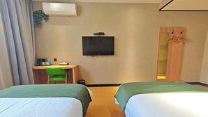 Une chambre d’hôtel avec deux lits, un bureau avec une chaise, une télévision et une armoire.