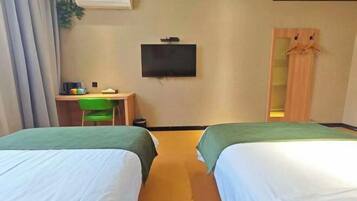 Ein Hotelzimmer mit zwei Betten, einem Schreibtisch mit Stuhl, einem Fernseher und einem Kleiderschrank.
