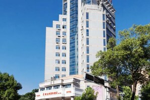 A multi-story hotel building with a prominent glass facade and signage indicating it is a hotel. - Vienna International Hotel (Chenzhou Wuling Square) (Chenzhou)