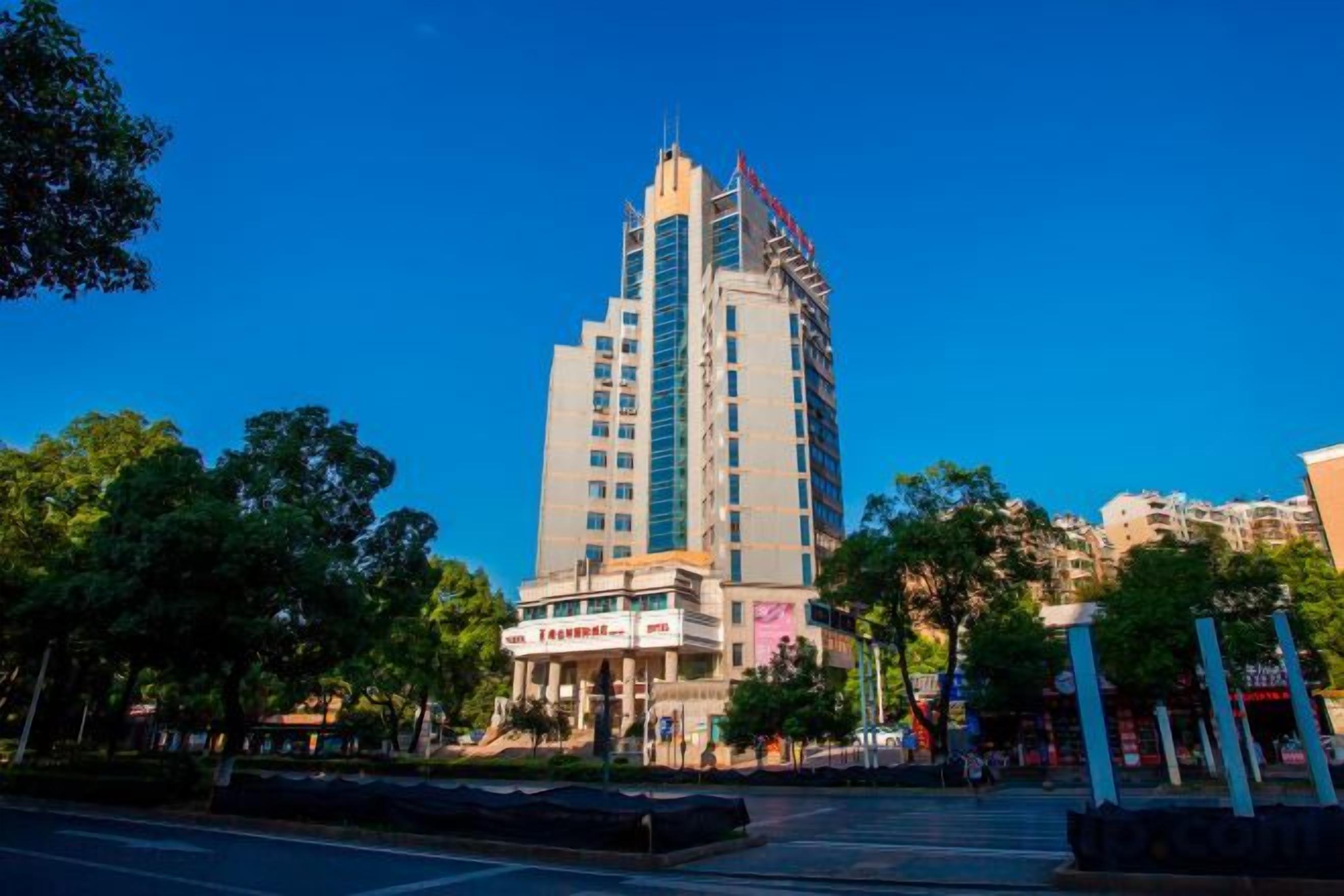 A tall hotel with multiple floors, a prominent entrance, and a surrounding urban environment.