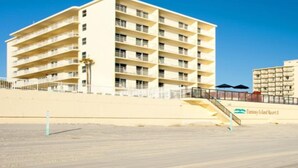 Un hotel de varios pisos con balcones, cerca de una playa.