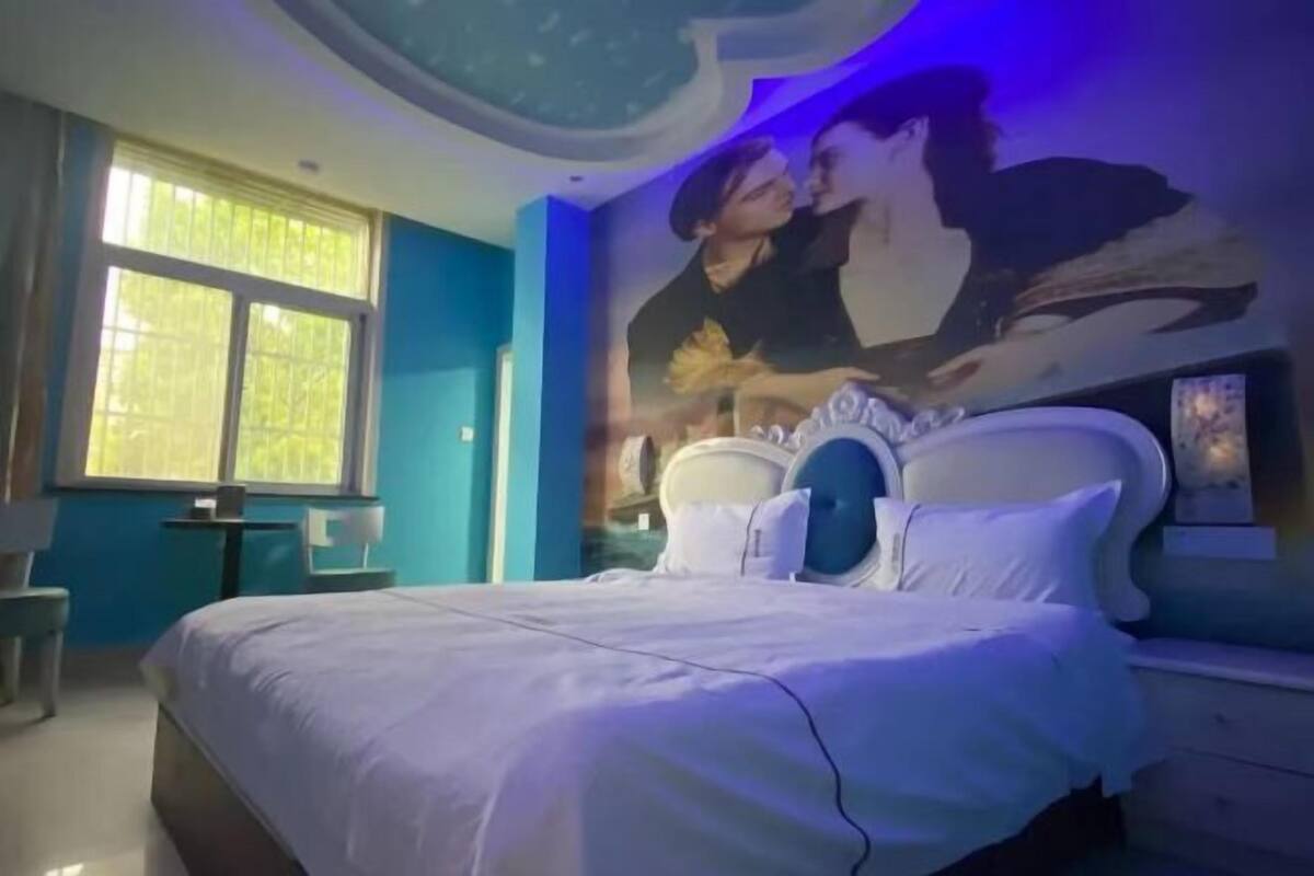 Une chambre à coucher avec un lit, une fenêtre, une peinture murale et une table de chevet.
