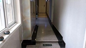 A hotel hallway with a carpeted floor, a handrail, and a sign indicating a baby changing area.