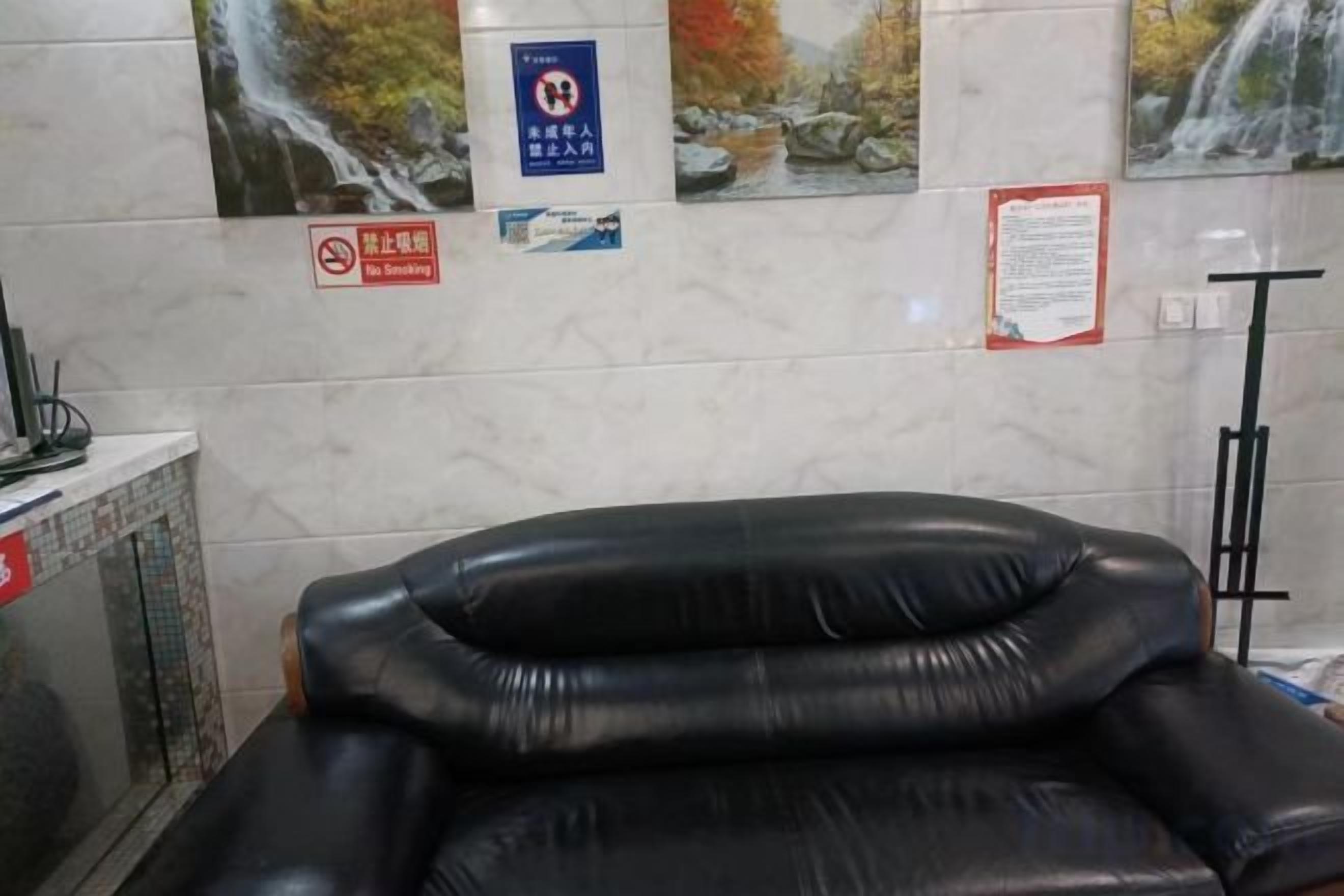 A room with a massage chair, a desk with a computer, and a wall with informational posters.
