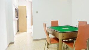 Una habitación con una mesa de billar, cuatro sillas y una puerta que da a otra estancia.