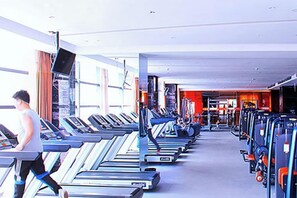 A gym with treadmills, exercise equipment, and a person running. - Tongren Jinjiang Hotel (Tongren)