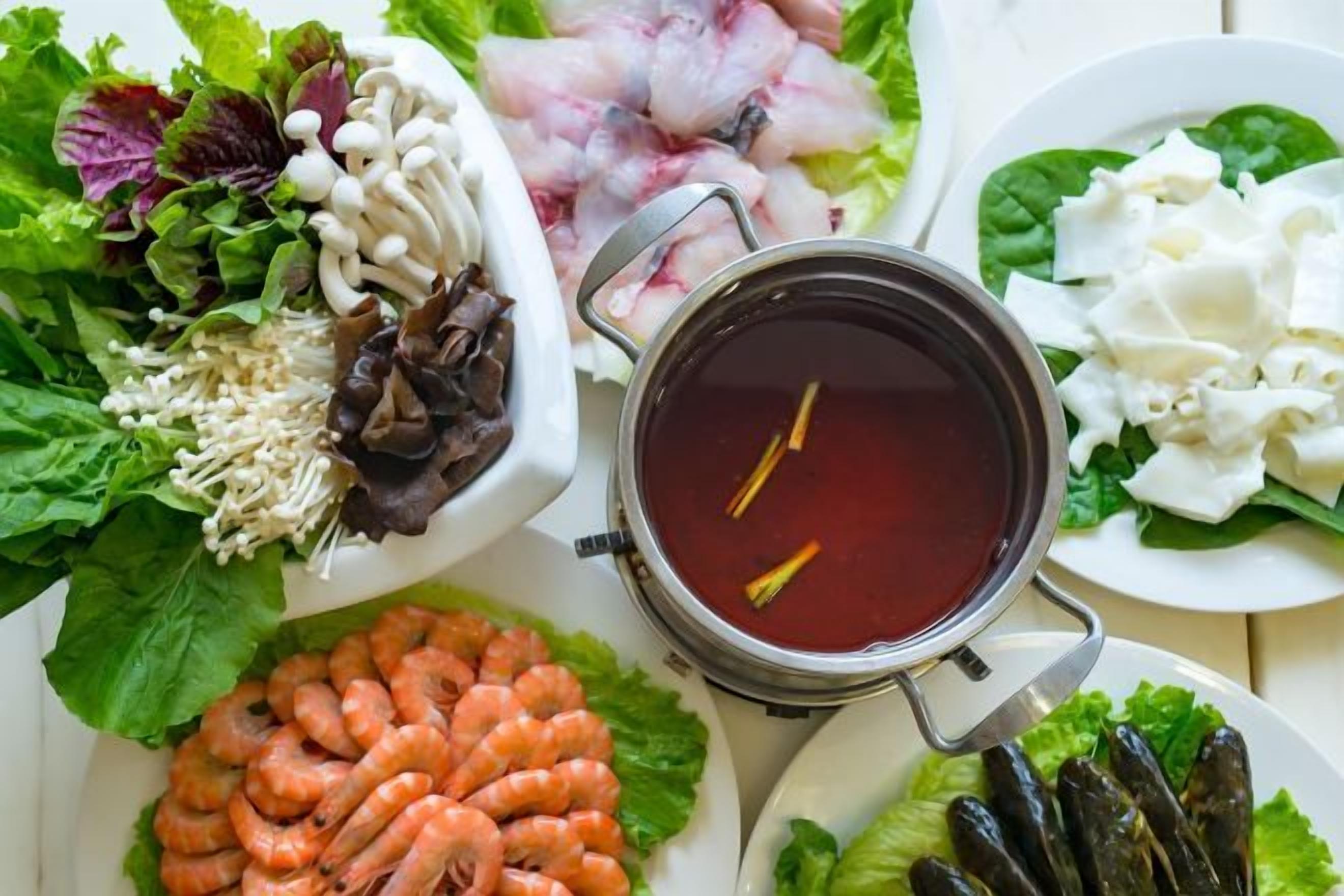 A table with various food items including shrimp, mushrooms, and vegetables.
