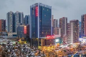 Un edificio de gran altura con fachada de vidrio moderna, rodeado de otros edificios altos en un entorno urbano.
