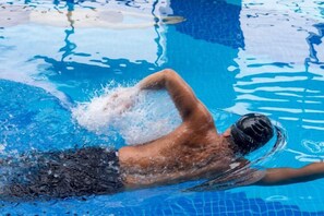 A swimmer in a pool with clear water and visible ripples. - Tongren Jinjiang Hotel (Tongren)