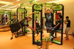 Un gimnasio con equipo de ejercicio, incluyendo barras de dominadas y máquinas de pesas.