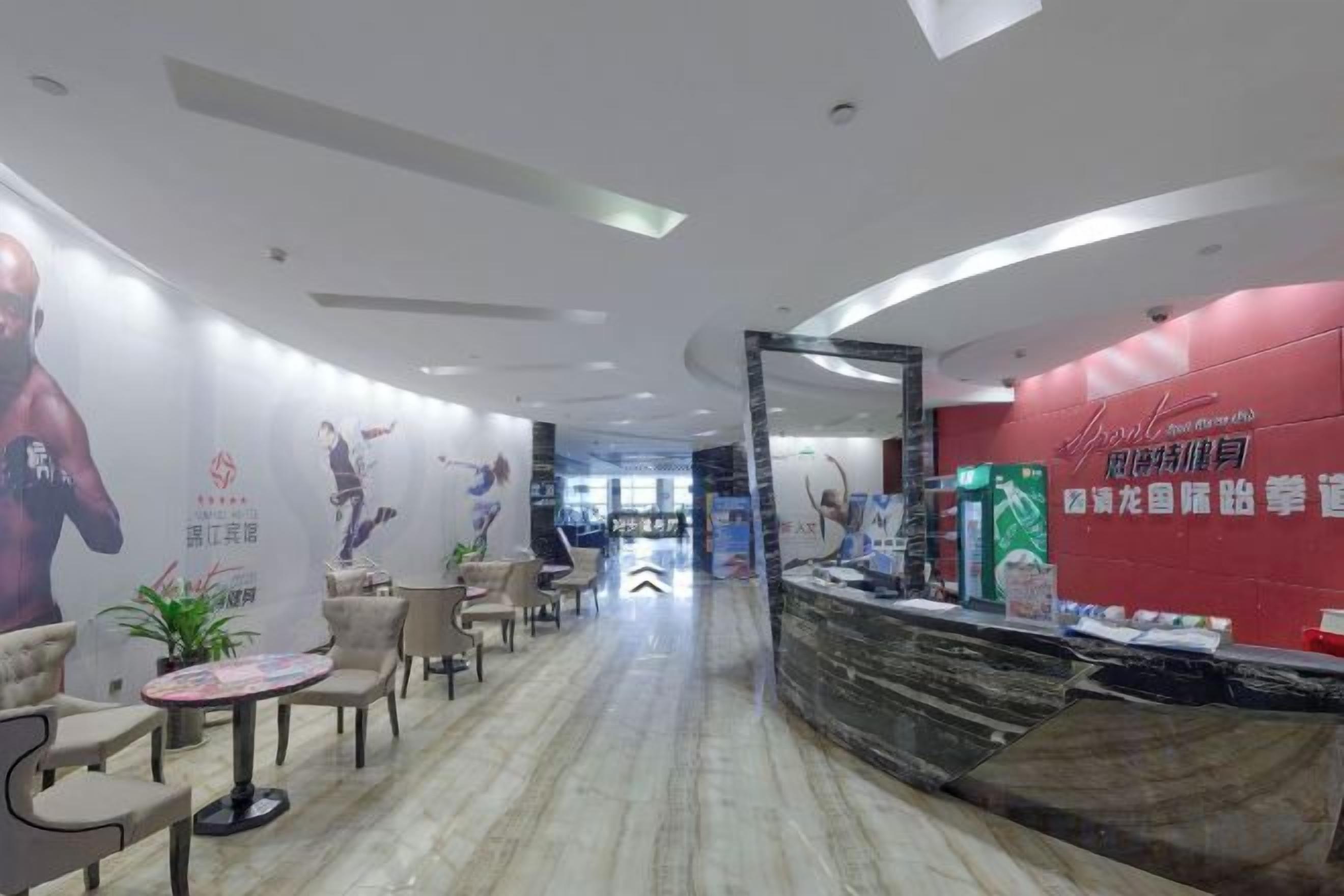 A hotel lobby with a reception desk, seating area, and a curved ceiling design.
