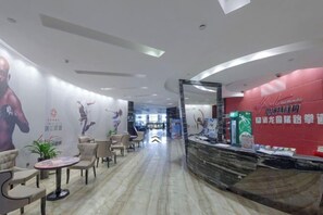 A hotel lobby with a reception desk, seating area, and a curved ceiling design. - Tongren Jinjiang Hotel (Tongren)