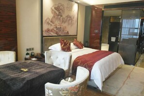 Una habitación de hotel con cama, una mesa, una silla y una obra de arte grande en la pared.