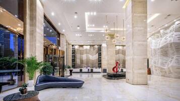 A spacious lobby with a seating area, a reception desk, and a large wall with text.