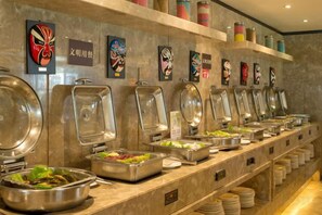 A buffet setup with multiple food stations, each with a covered serving dish. - Tongren Jinjiang Hotel (Tongren)