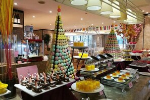 A hotel lobby with multiple Christmas trees, a buffet with various food items, and a seating area. - Tongren Jinjiang Hotel (Tongren)