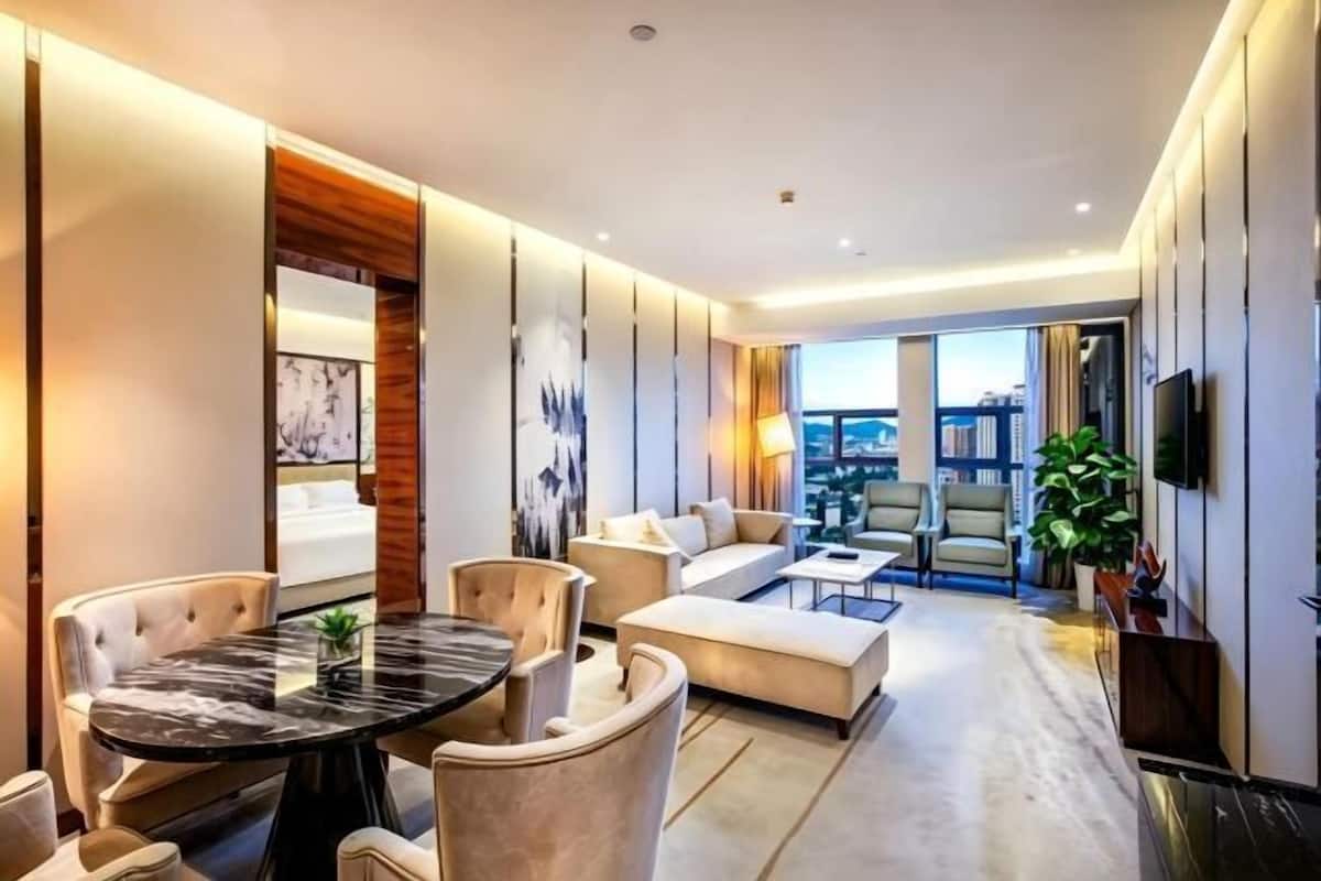 Una sala de estar moderna con una mesa redonda, sofás y una televisión.