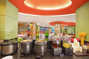 Eine Küchenzeile mit diversen Kochgeräten und Utensilien, darunter große Töpfe, eine Kaffeemaschine und eine Tee-Ecke.