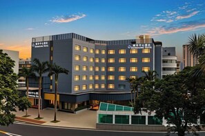 A modern hotel with a curved facade, multiple floors, and a well-lit entrance. - Zhuhai City Center Hotel (Zhuhai)