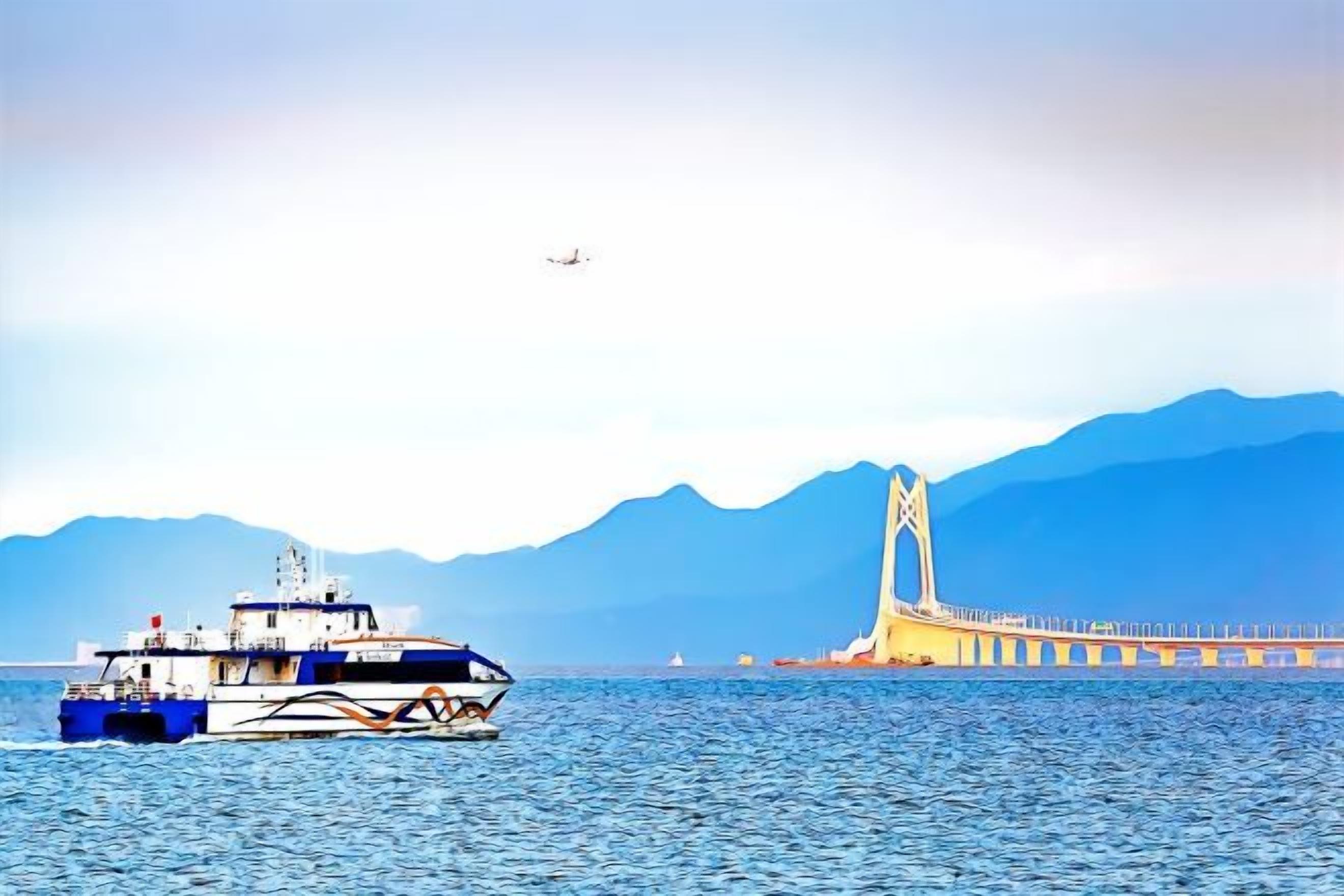 A ferry boat on a body of water with a bridge and mountains in the background.