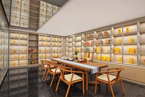 Un intérieur moderne comprenant un coin repas, de nombreuses étagères remplies d’objets et un escalier.