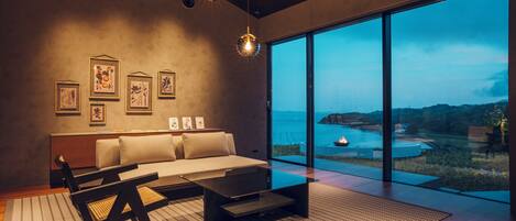 A modern living room with a sofa, coffee table, and artwork on the wall.