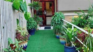 Un sendero estrecho con césped artificial que conduce a la entrada de un edificio.