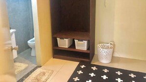 A bathroom with a dark wooden cabinet, a white basket, and a patterned rug.