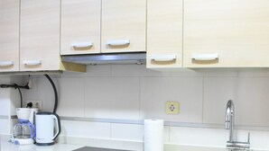 Cucina con mobili in legno, una moka e un lavandino.
