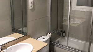 A bathroom with a sink, toilet, and shower. - TWO-BEDROOM APARTMENT (Barcelona)