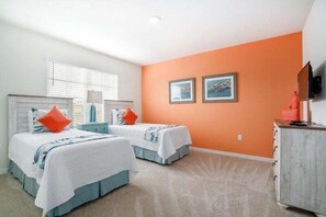 A hotel room with two beds, a television, and a dresser.