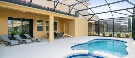 An indoor swimming pool with a glass ceiling, lounge chairs, and a sun terrace.