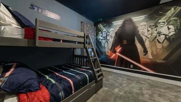 En køjeseng med et vægmaleri med Star Wars-tema.