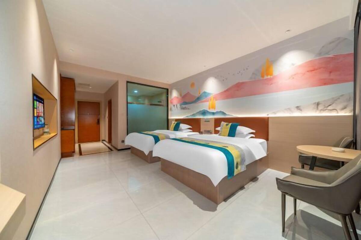 Une chambre d’hôtel avec deux lits, une petite table et une chaise.